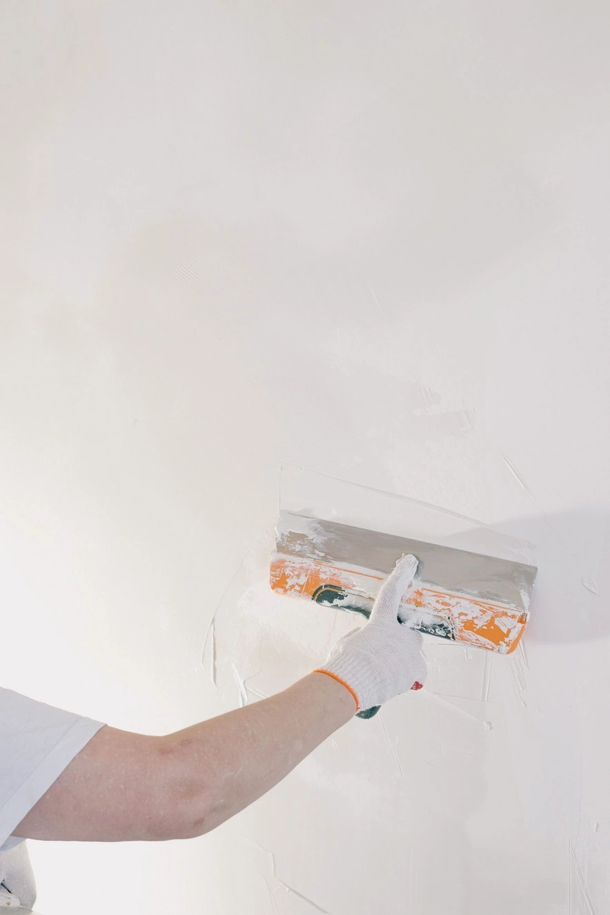 Skim coating a wall with a wide trowel before painting