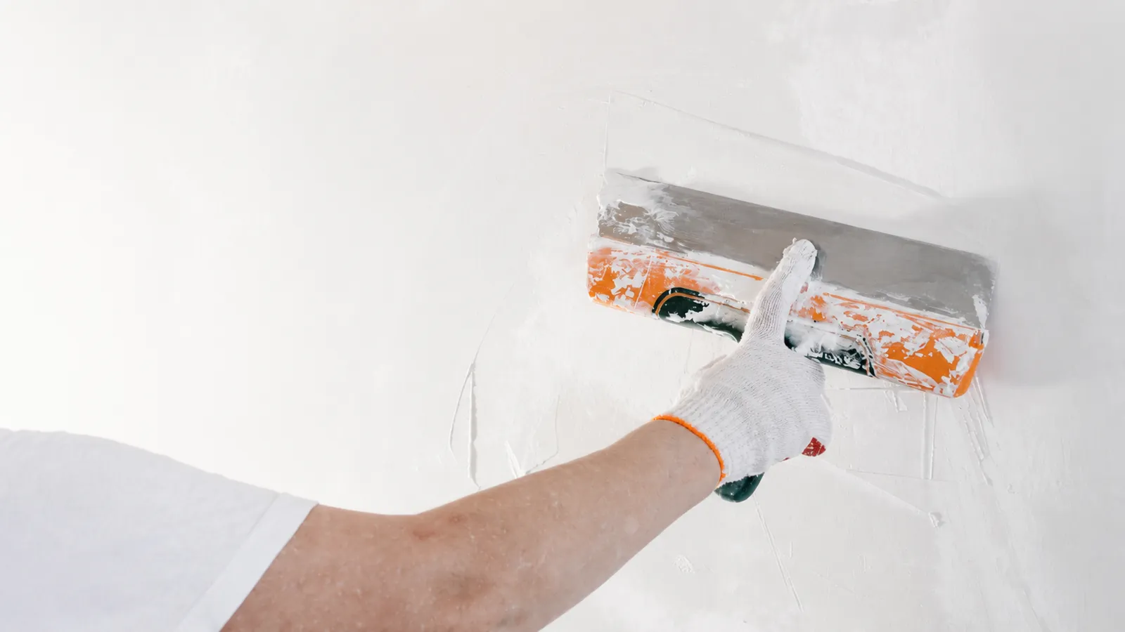 Skim coating fiberglass wallpaper with a wide trowel